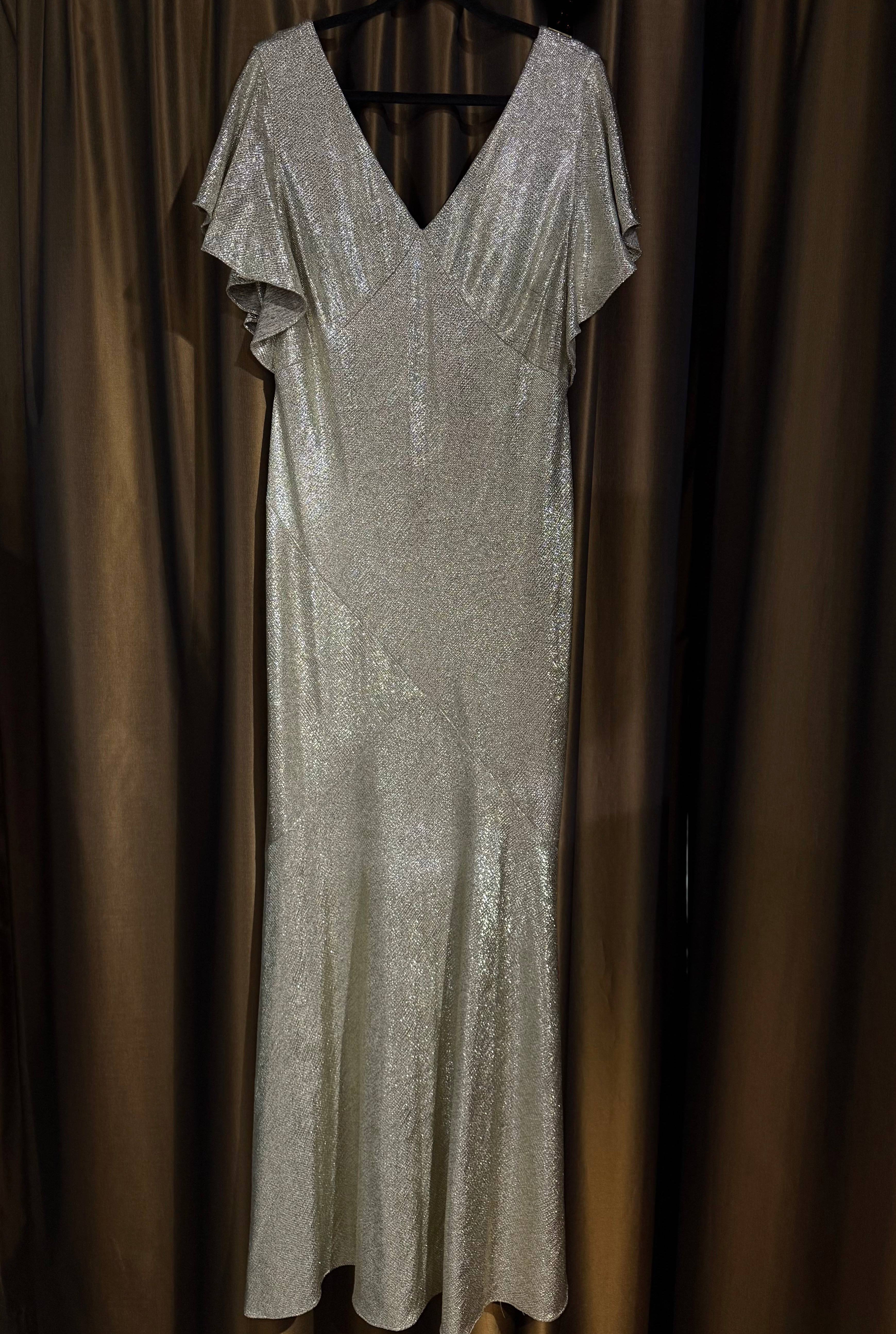 Upeasti laskeutuva kultainen iltapuku.