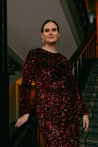 Kalla-paljetti-iltapuvun yksityiskohta: punainen paljettikangas ja elegantti leikkaus, Anette Ahokas Design.