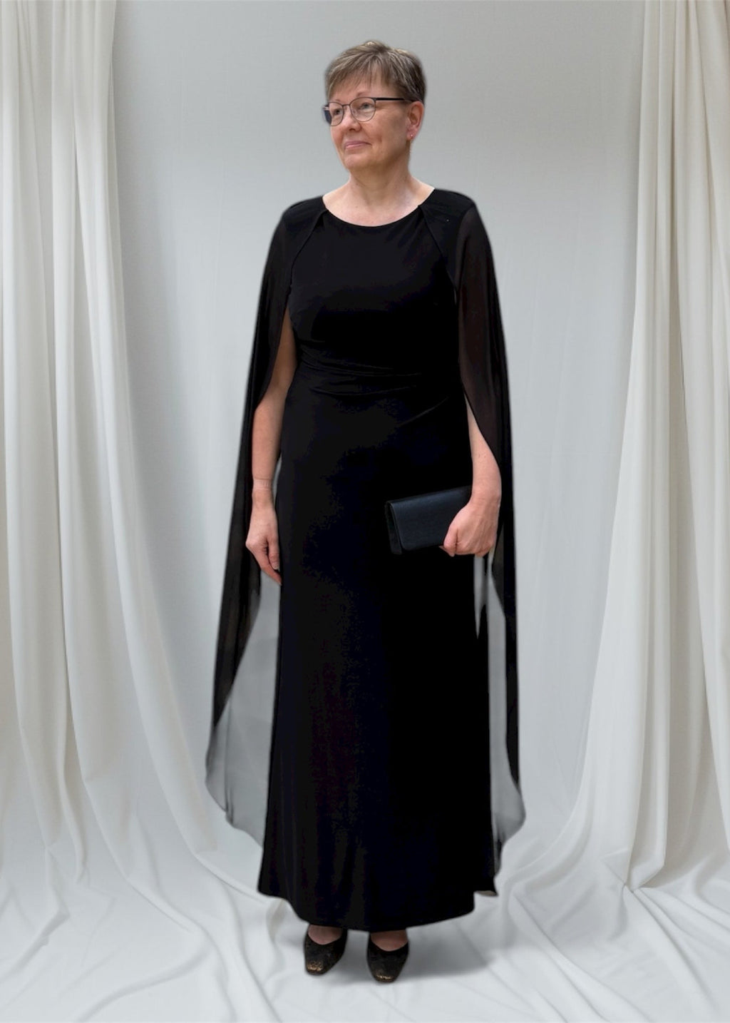 Musta iltapuku, jossa sifonkiviitta harteilla.