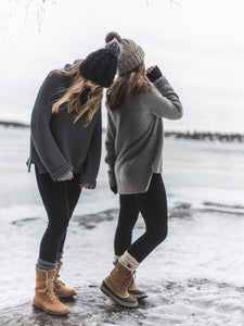 Kaksi naista ovat meren jäällä merinovillalengginsit jalassa.